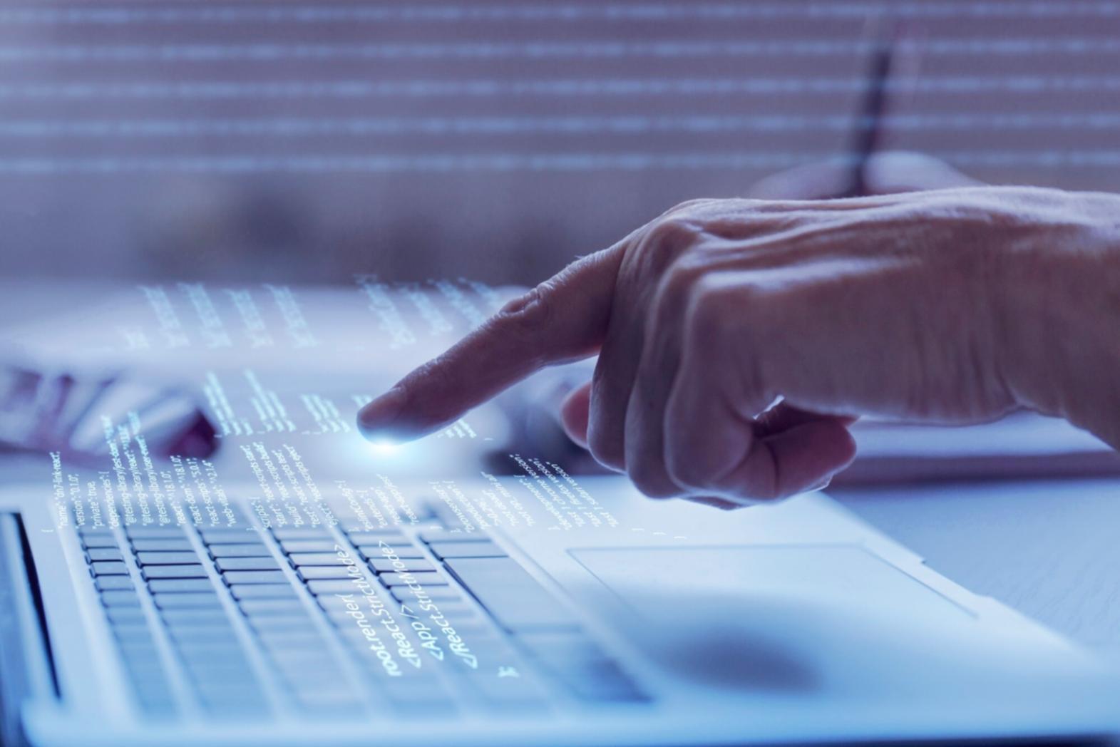 Person arbeitet an einem Laptop mit zugänglichen Webdesign-Elementen auf dem Bildschirm